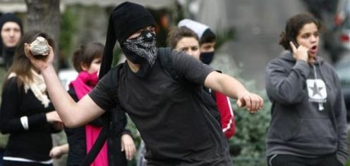 1-a-youth-throws-stones-at-police-during-a-rally-in-central-athens_334