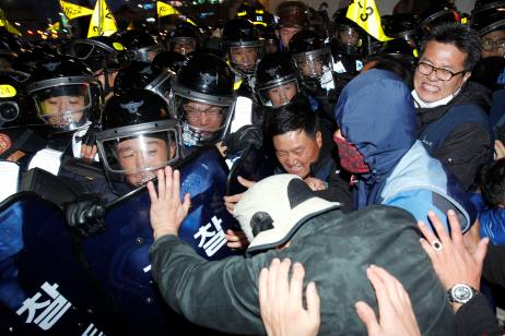 Protesters struggle with riot police as they try to march during a rally in central Seoul