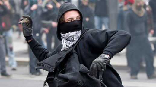 800_que_msked_protester_rock_cp_120420