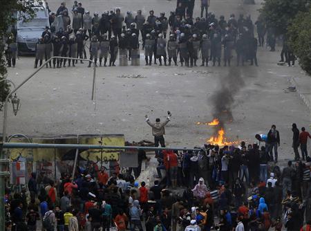 A protester gestures at riot police during a demonstration at Qasr al-Aini Street near Tahrir Square in&nbsp;Cairo