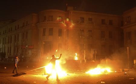 A protester throws rocks during clashes with police in front of the High Court in&nbsp;Cairo