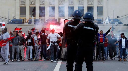 Fans face riot Gendarmes in front of the Eiffel Tower after clashes between fans and police as several thousand supporters celebrated with Paris Saint-Germain soccer players who received the French Championship trophy in&nbsp;Paris