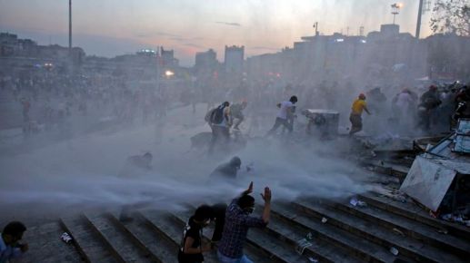 People run as riot police fires a water cannon on Gezi Park protesters at Taksim Square in&nbsp;Istanbul