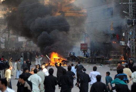 565804-des-habitants-de-rawalpindi-se-rassemblent-pres-de-magasins-incendies-apres-des-heurts-pendant-une-p