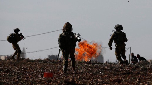 Israeli soldiers stand near a fire during clashes with Palestinian protesters in Jalazoun refugee camp near&nbsp;Ramallah