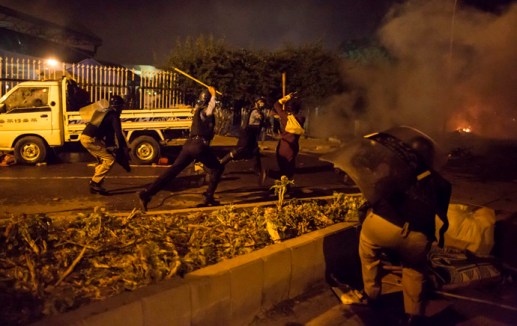 Riot police run after a supporter of Tahir ul-Qadri, Sufi cleric and leader of political party PAT, outside the parliament house as the supporters marched towards the prime minister’s house in Islamabad