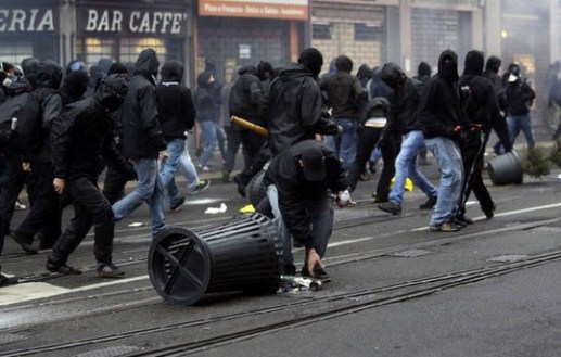 Scontri-No-Expo-Milano-2015-con-polizia-bruciano-auto-e-negozi-palazzi-in-fiamme